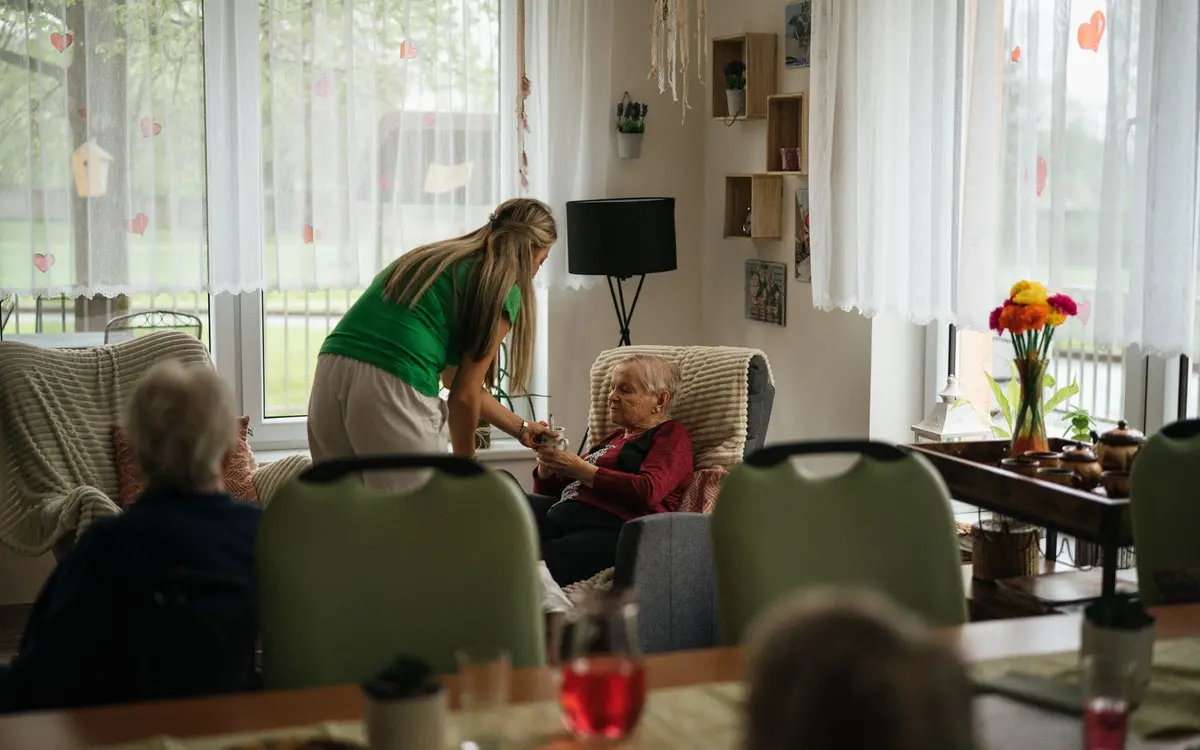 Accompagnement de résidents dans une salle commune d'établissement