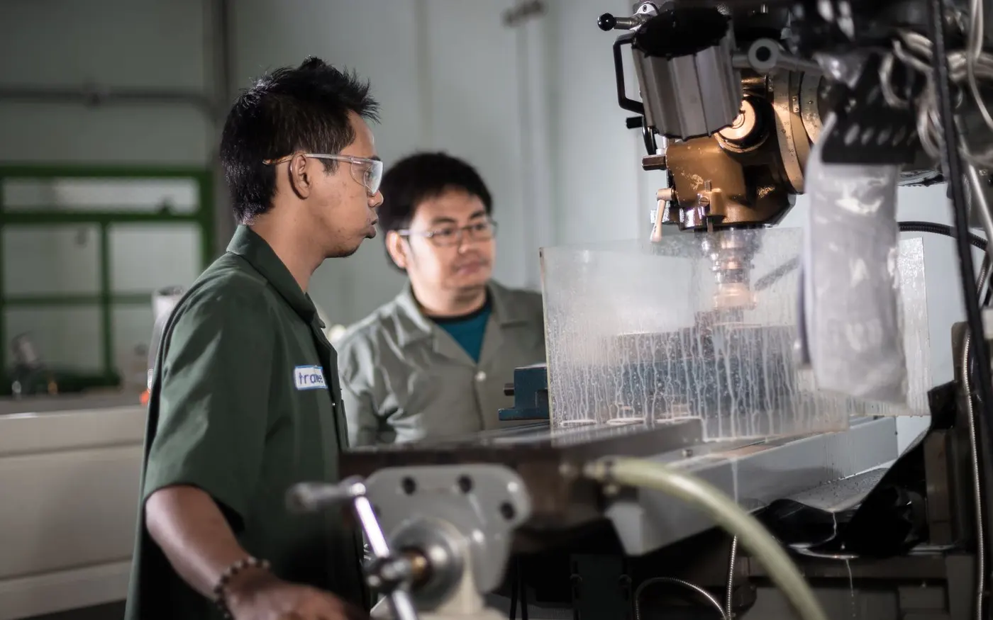 Techniciens conduisant une machine-outil dans un atelier industriel