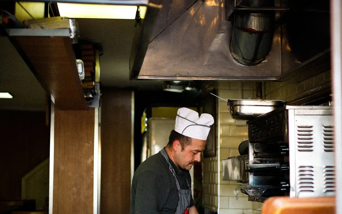 A cook at their station in a restaurant kitchen
